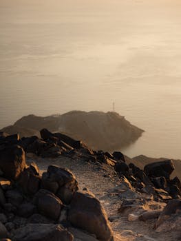 A tranquil rocky path with ocean view during sunset, capturing the serene beauty of Khor Fakkan, UAE.