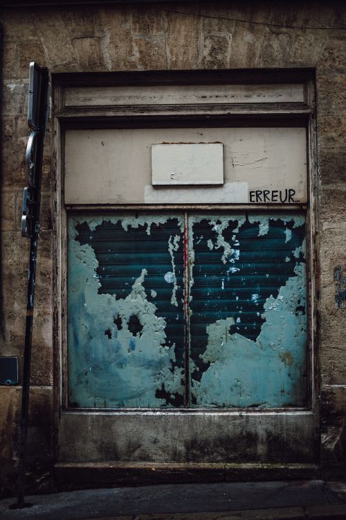 Free An old urban door with peeling blue paint and graffiti. A concept of decay and urban life. Stock Photo