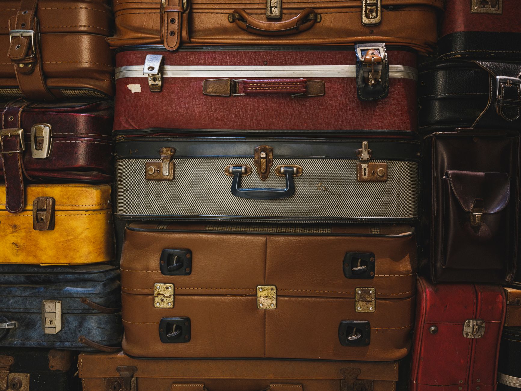 A collection of vintage suitcases stacked together, showcasing retro travel charm.