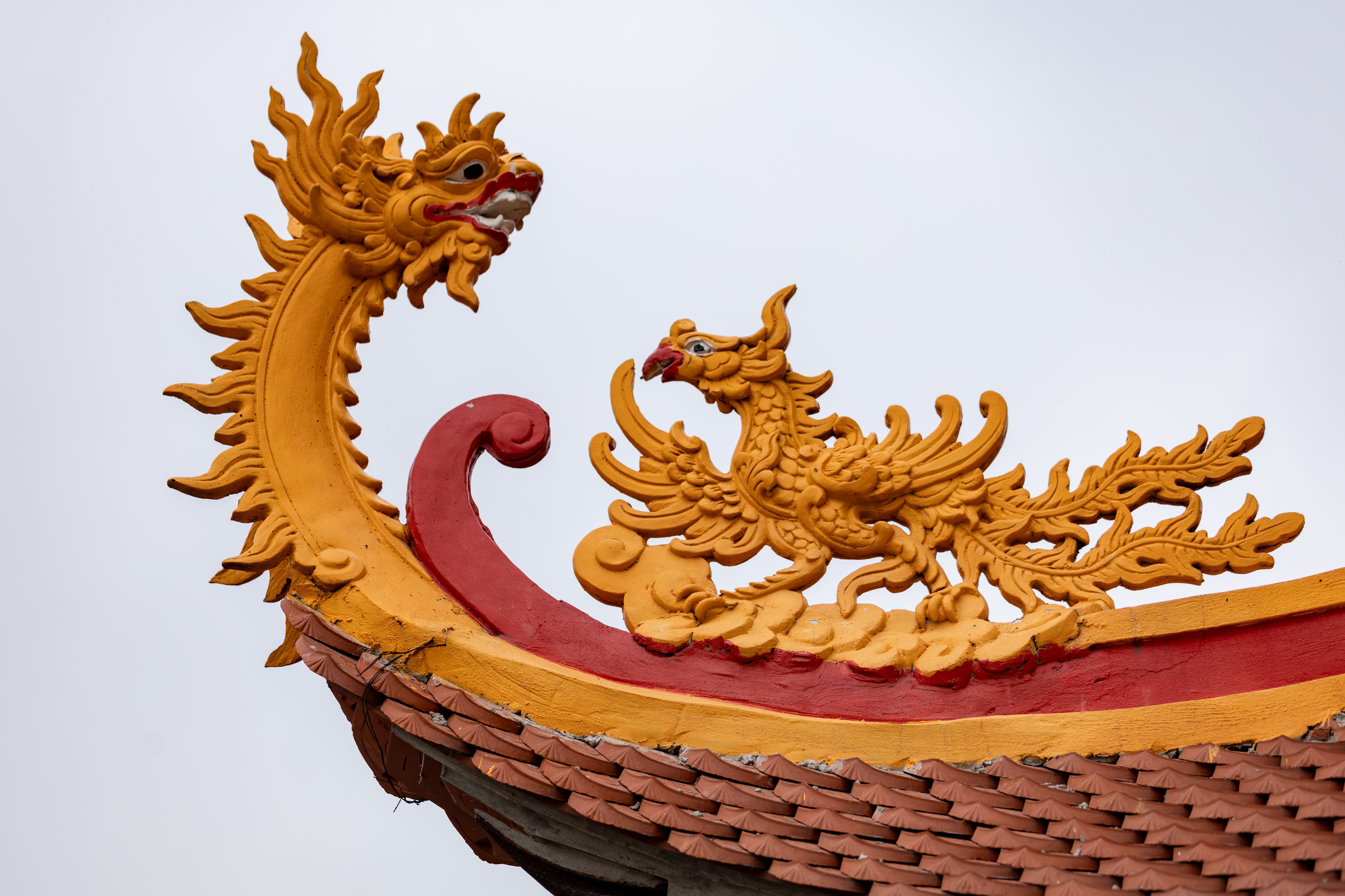 Close-up of a vibrant dragon ornament on a temple rooftop in Hà Nội, Việt Nam, showcasing traditional design.