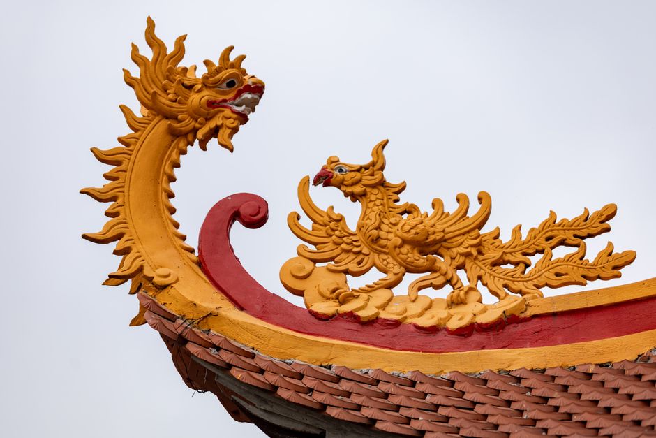 Close-up of a vibrant dragon ornament on a temple rooftop in Hà Nội, Việt Nam, showcasing traditional design.