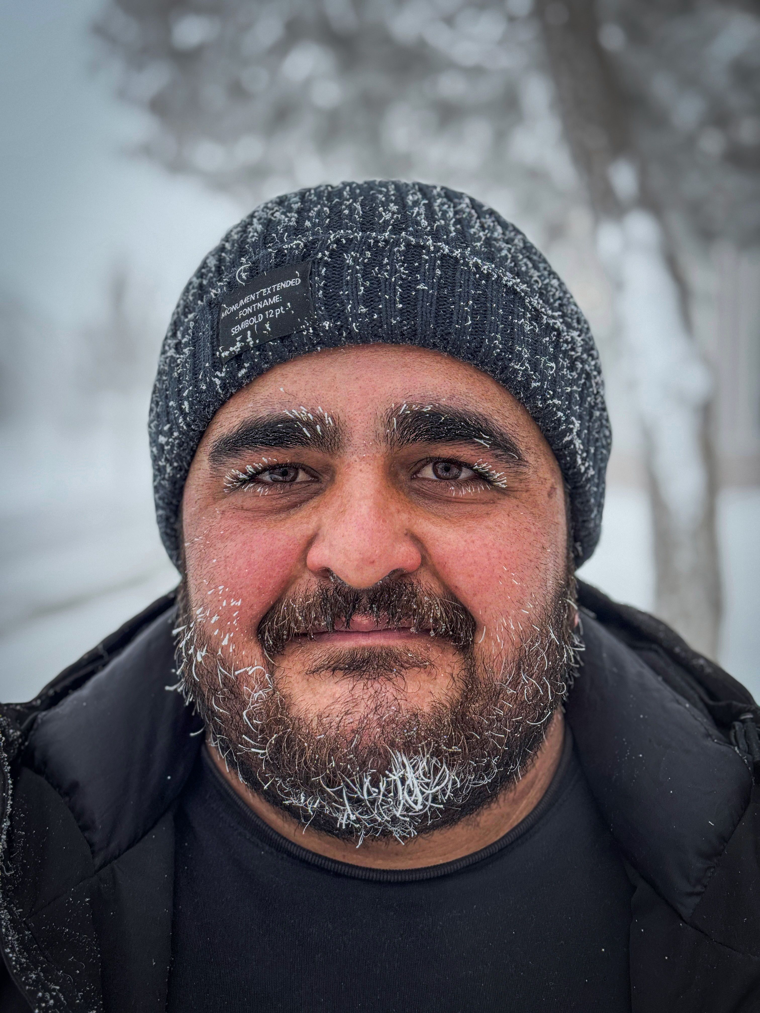 Close-up portrait of a man with hoarfrost in his beard in snowy Ağrı, Türkiye.