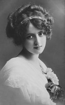 Elegant vintage portrait of a woman with curly hairstyle and white dress.