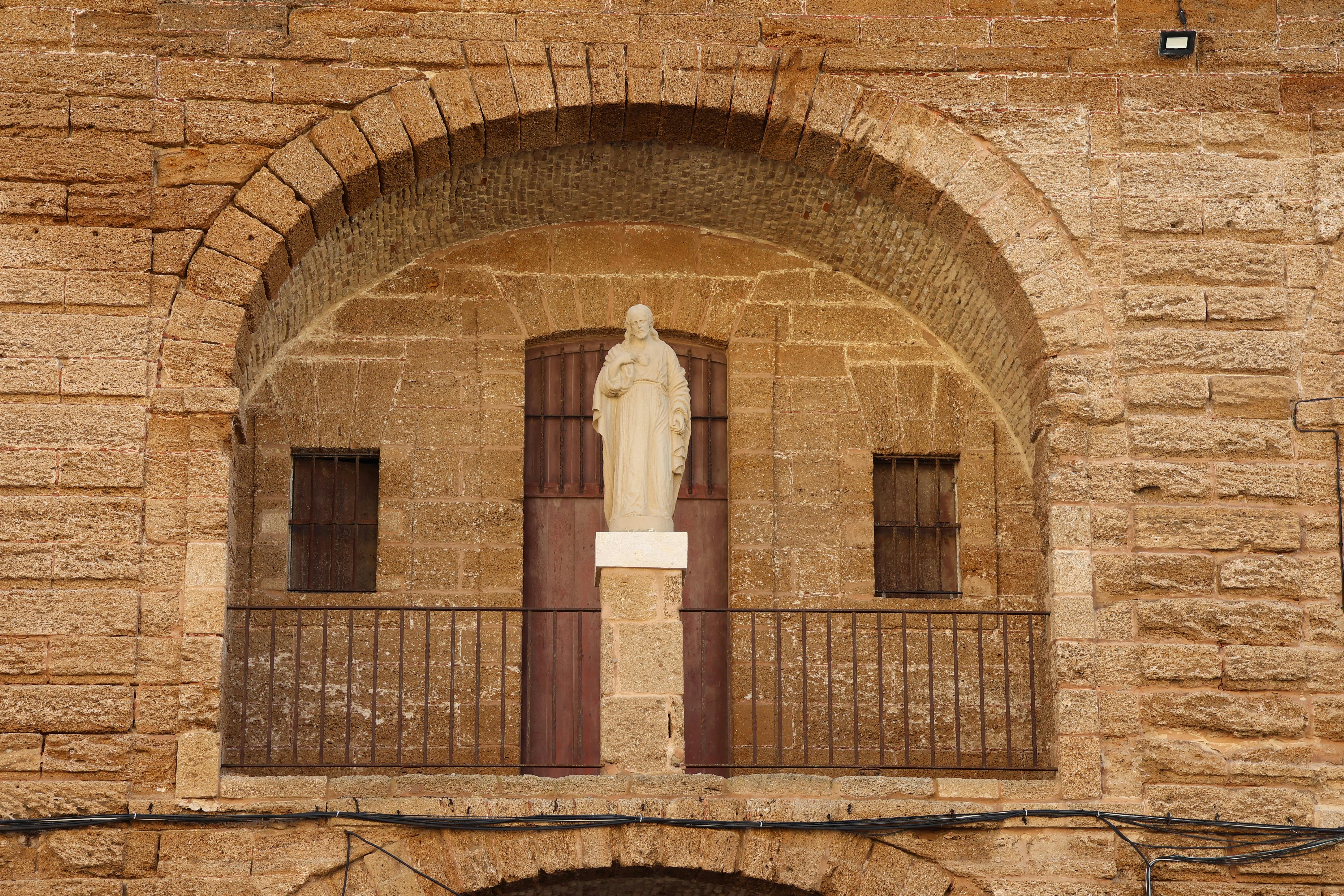 Stone fortification and statue in Cádiz, Spain highlights rich heritage. - Cádiz