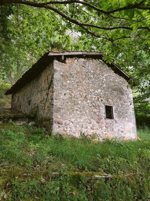 Free A quaint stone structure surrounded by greenery in the picturesque setting of Cangas de Onís, Spain. Stock Photo