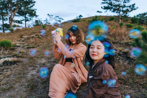 Photo Of Women Playing With Bubbles