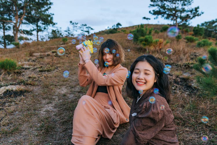 Photo Of Women Playing With Bubbles