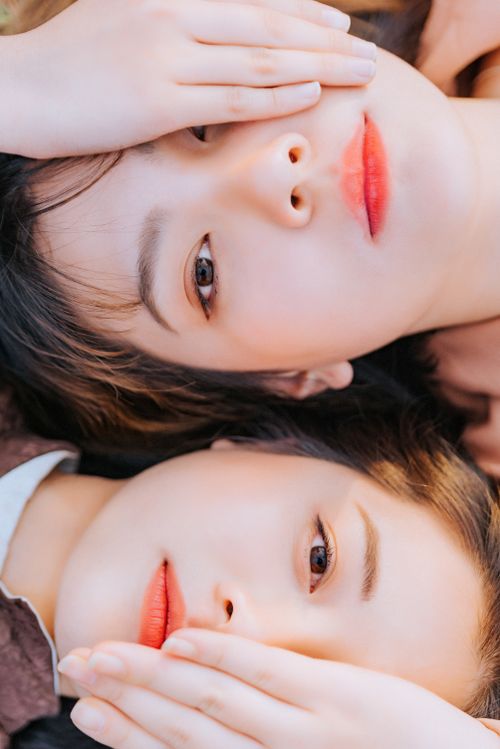 Free Intimate close-up of two women lying together outdoors, showcasing natural beauty and connection. Stock Photo