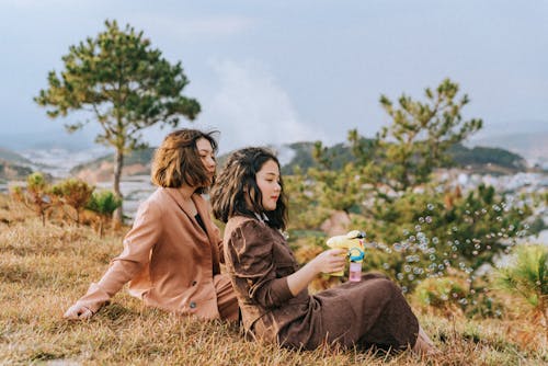 Two Women Sitting on Ground