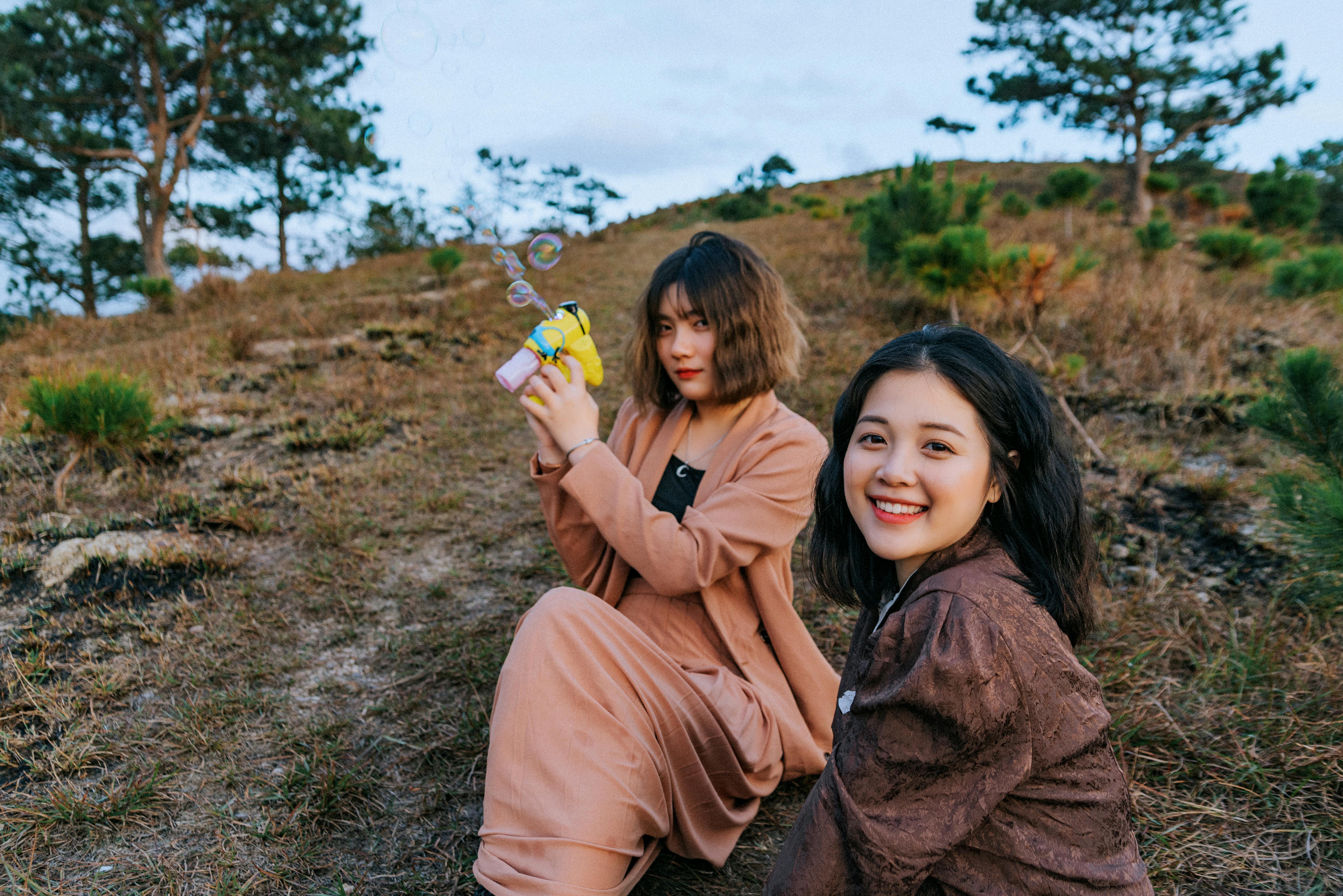 photo of women sitting on grass