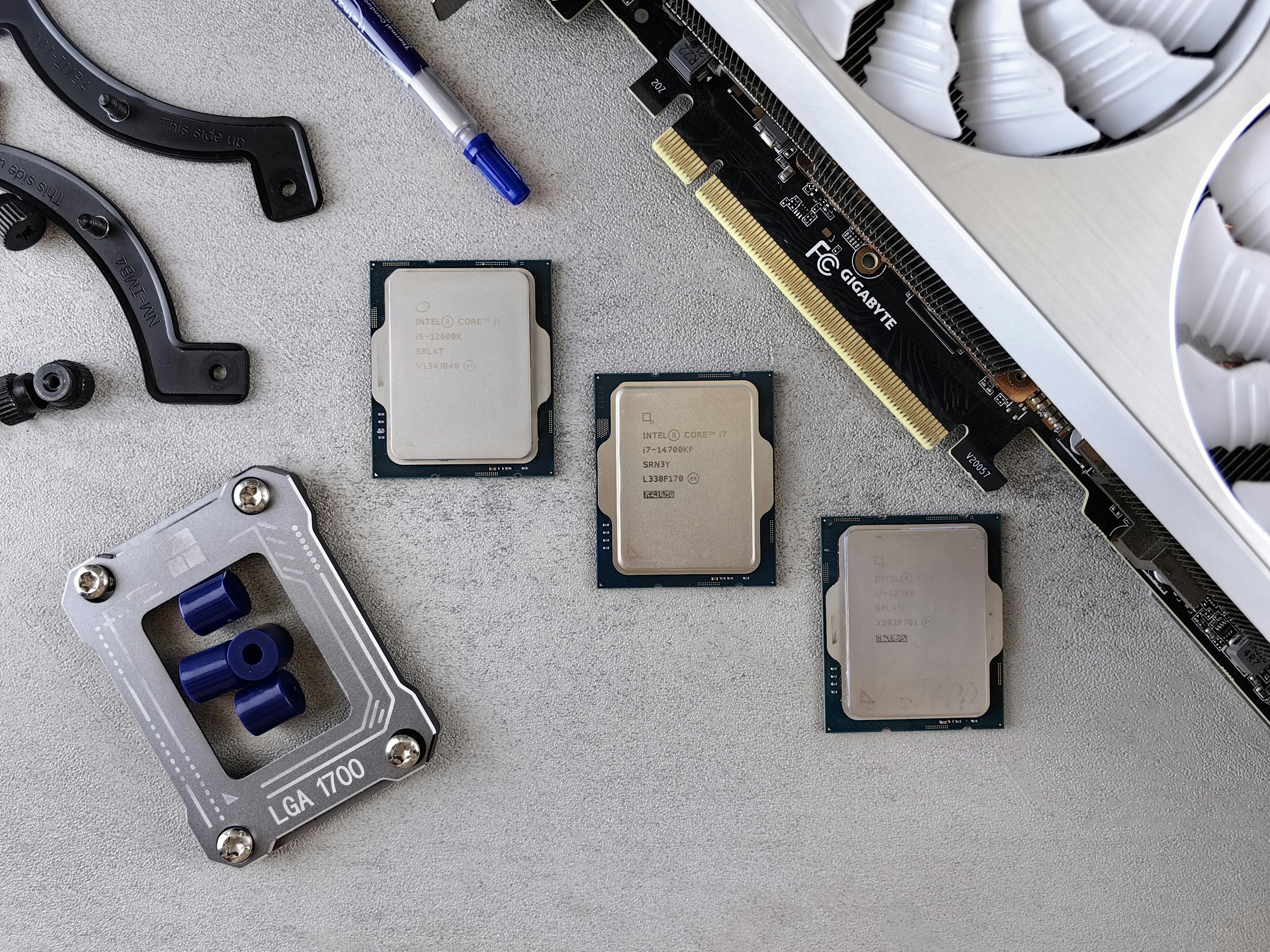 Overhead view of CPUs, graphics card, and mounting equipment on gray background, emphasizing modern technology.