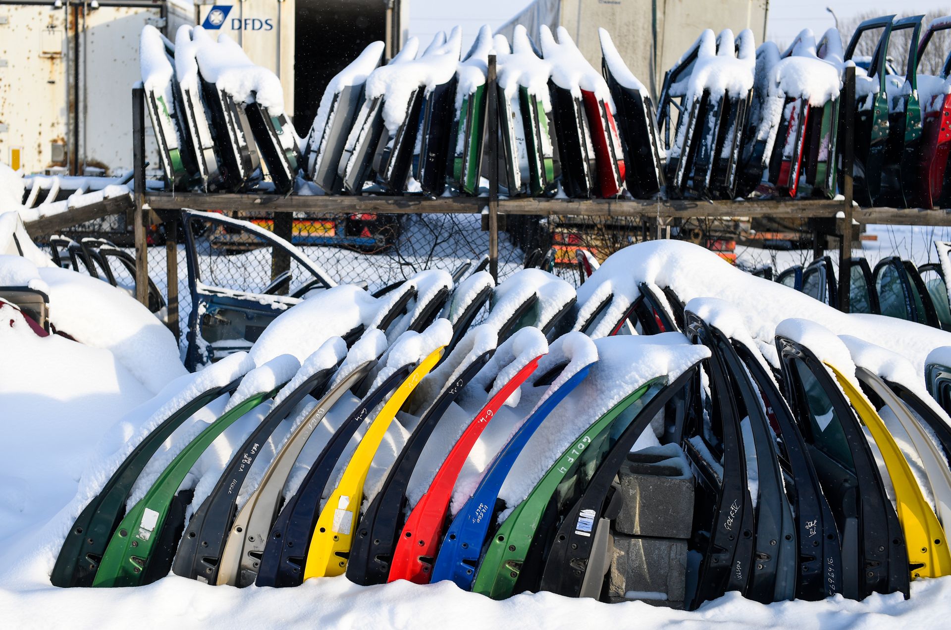 Fahrzeugtüren mit Schneeresten in einer winterlichen Materialzone.