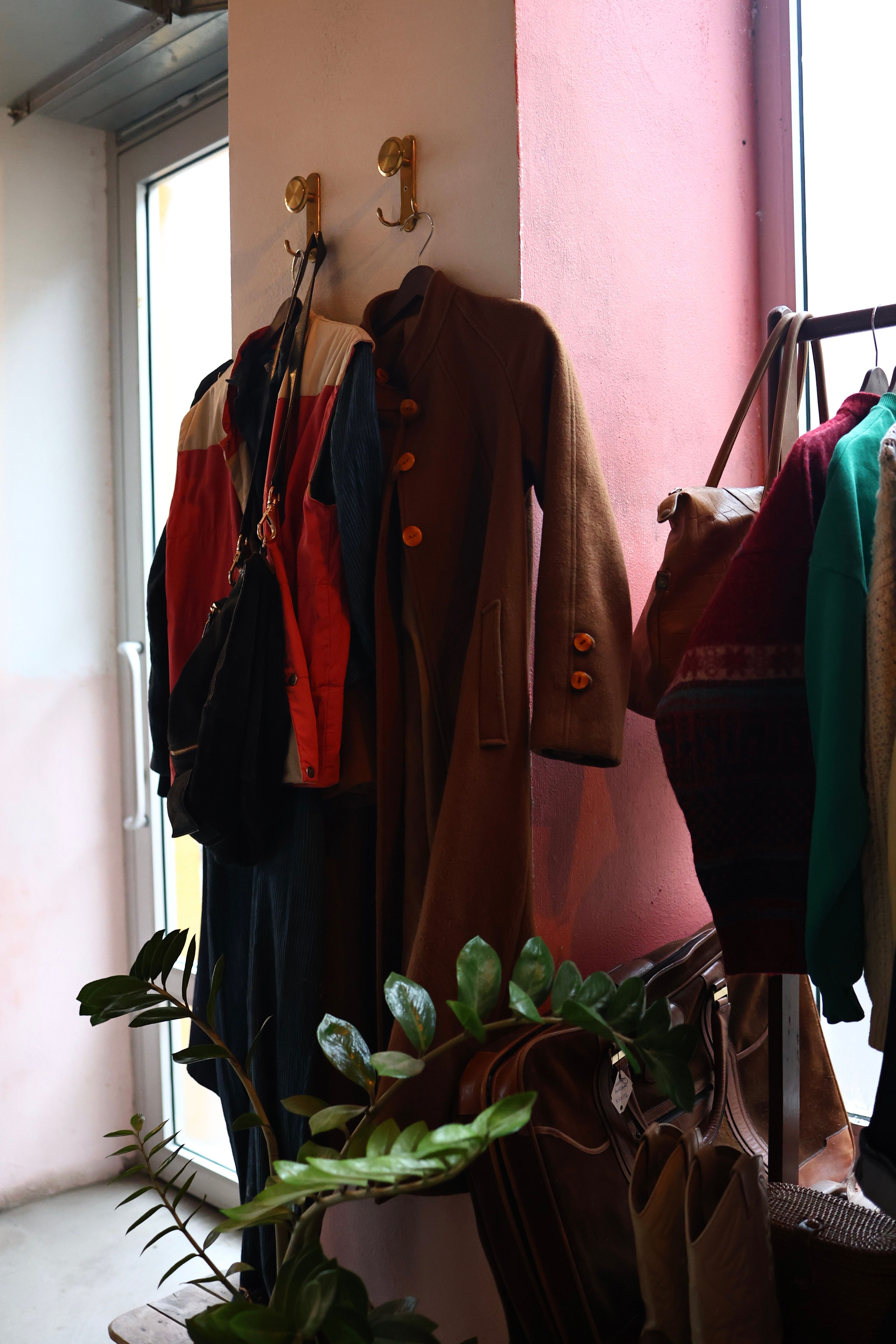 Vintage coats hanging in a sunlit shop corner — photo by Esmanur Güler on Pexels