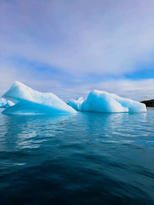 Free Stunning view of blue icebergs floating in Iceland's serene waters under a clear sky. Stock Photo