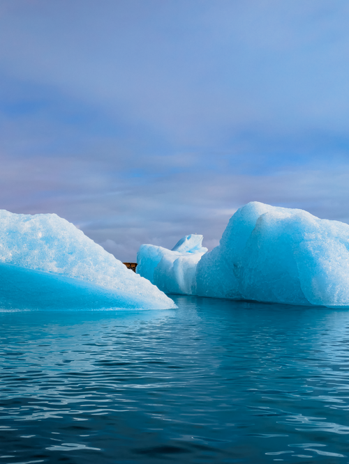 Free Serene view of icebergs floating in crystal-clear water in Iceland's breathtaking landscape. Stock Photo