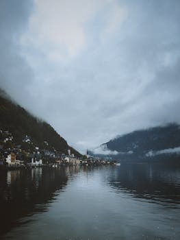 Ethereal view of Hallstatt town by the lake amidst misty mountains