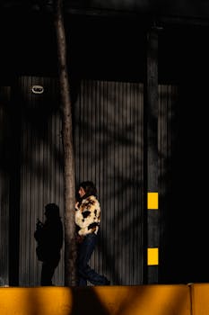 Artistic street photo capturing a woman in dramatic shadows in Barcelona.