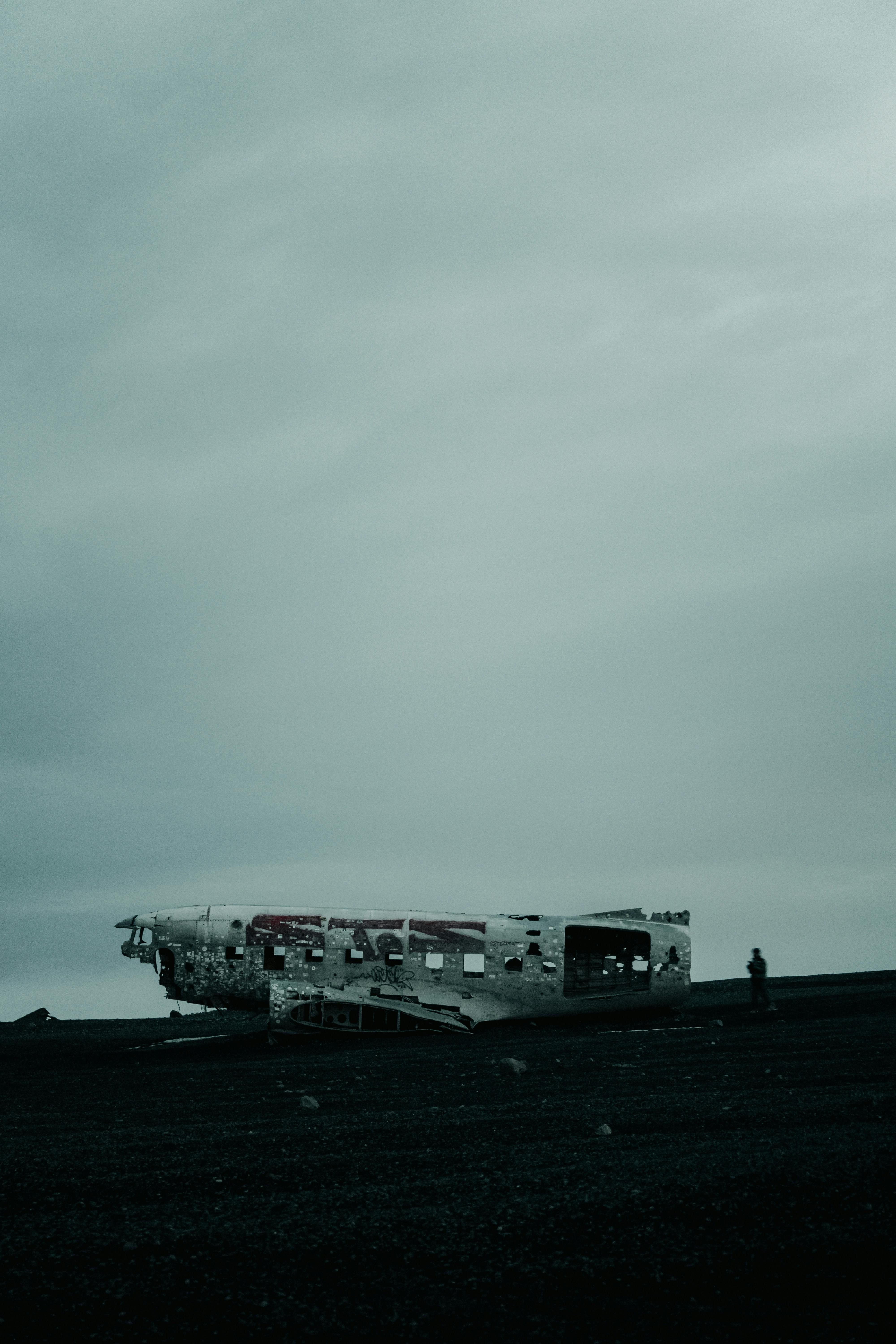 Gratis Stemningsfuldt billede af et flyvrag på Islands sorte sand med overskyet himmel. Lagerfoto