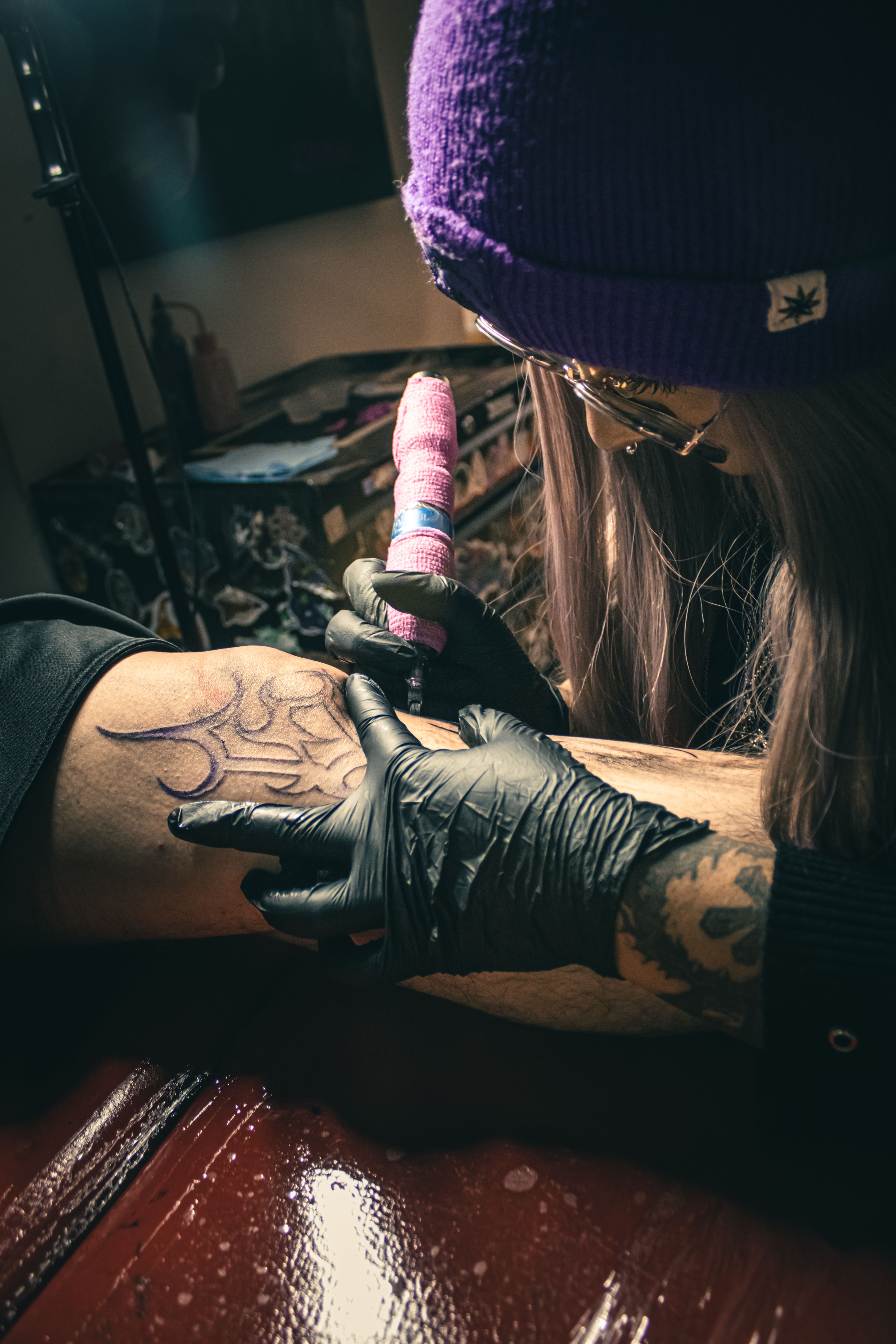Artist creating intricate tattoo design on client's arm in a Ciudad de México studio.