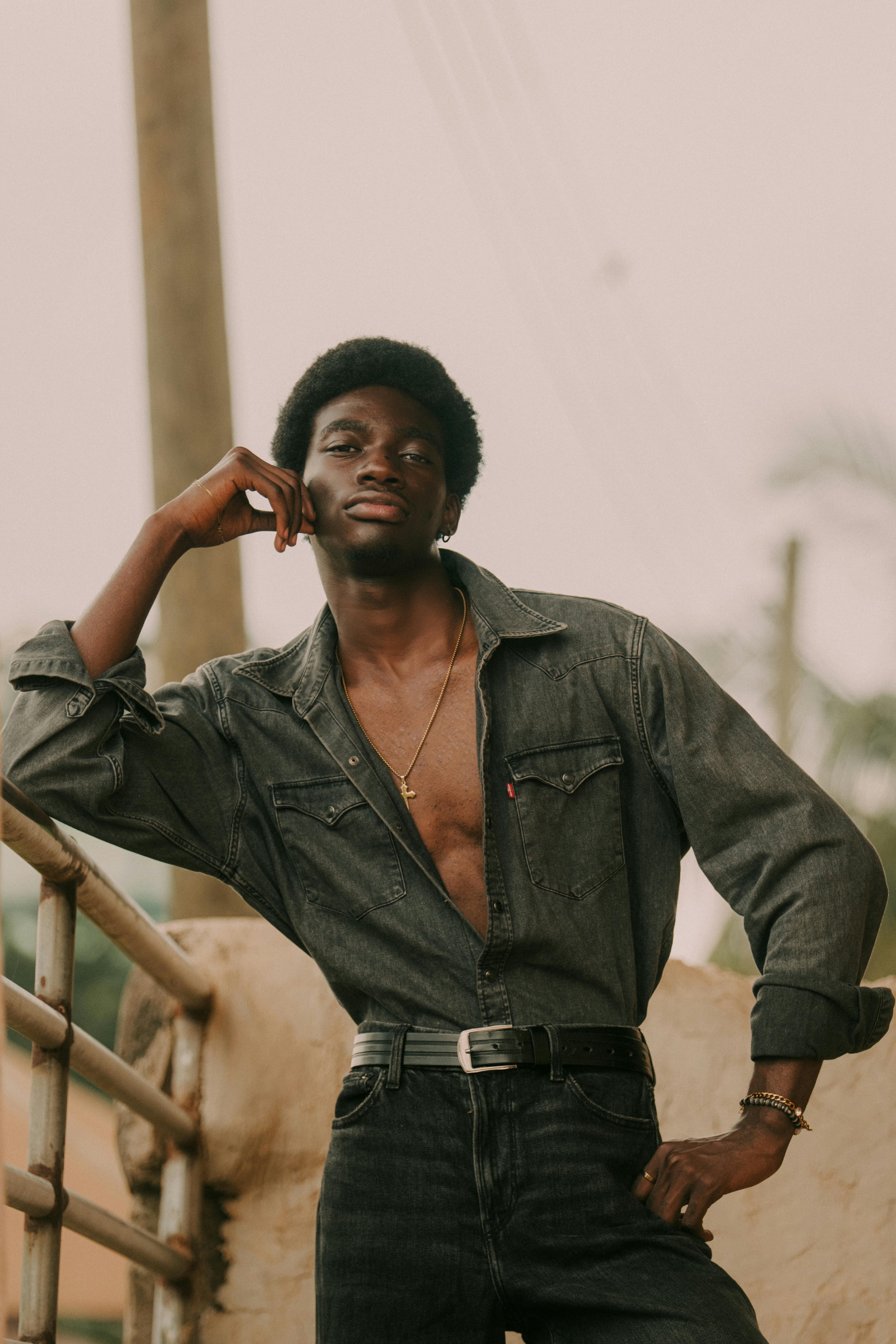 Confident young man posing outdoors in Ghana, showcasing modern and stylish fashion.