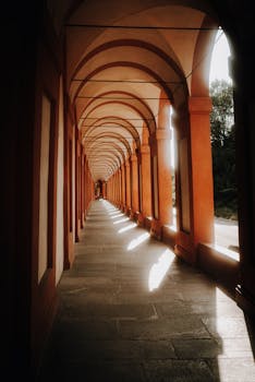 Explore the captivating sunlit corridors of an Italian portico, showcasing timeless architecture.
