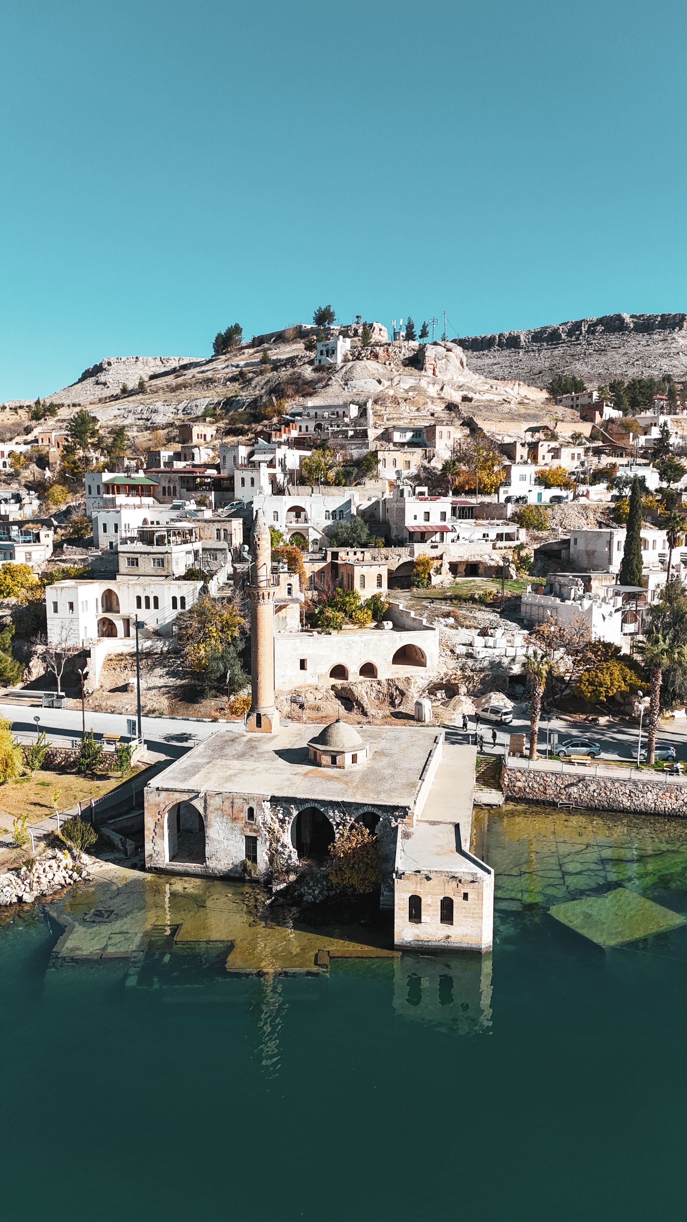 Aerial view of a submerged mosque and historical town on a sunny day.