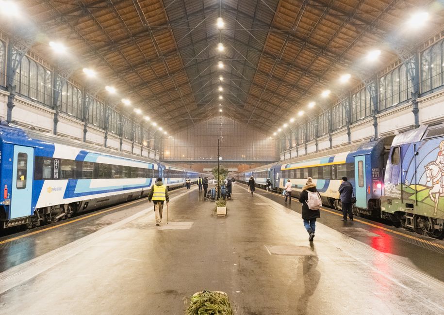 The grand interior of Budapest Keleti railway station, with passengers waiting for intercity trains in Hungary.