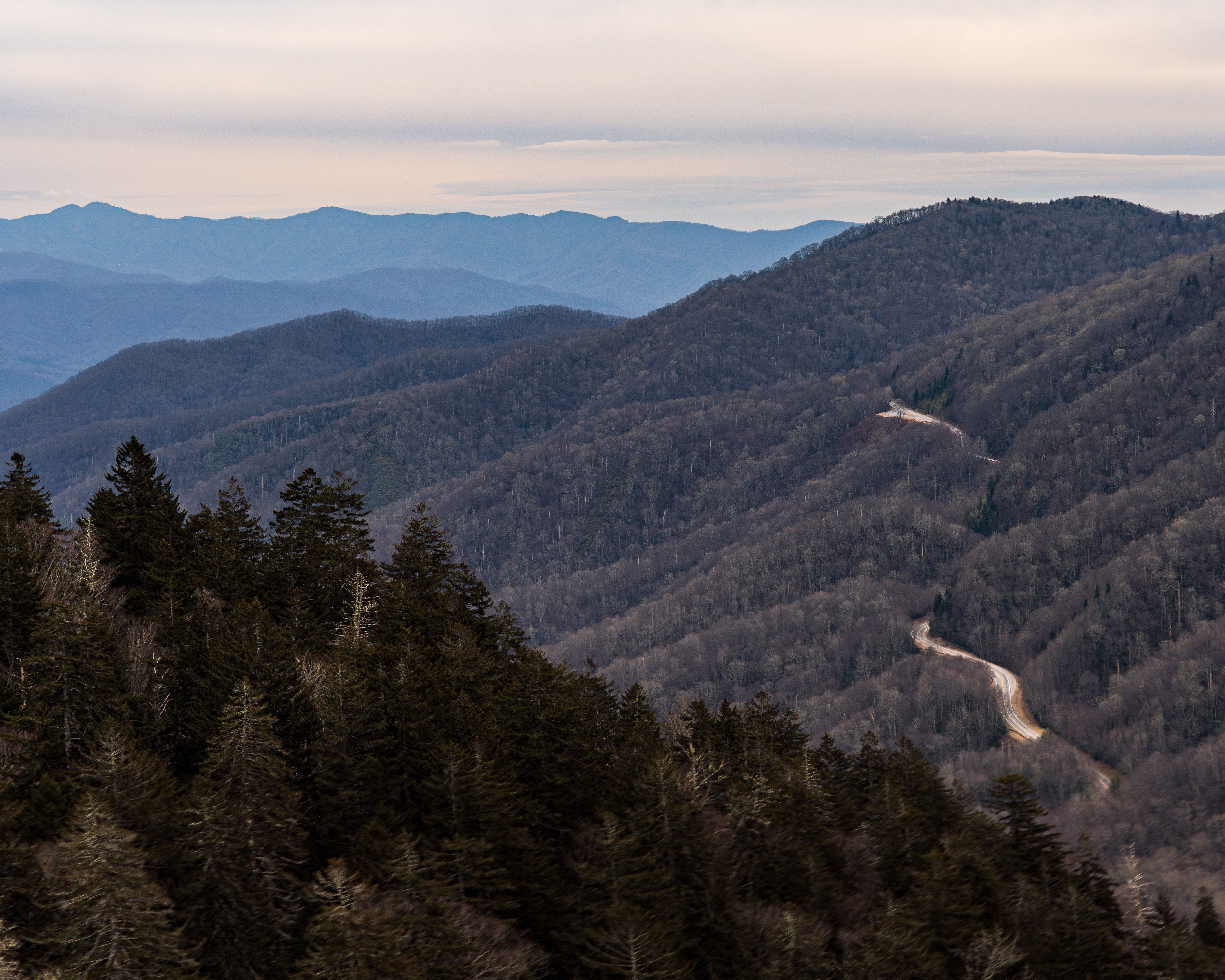 A captivating view of the Smoky Mountains with winding road, showcasing the serene winter landscape. A captivating view of the Smoky Mountains with winding road, showcasing the serene winter landscape.