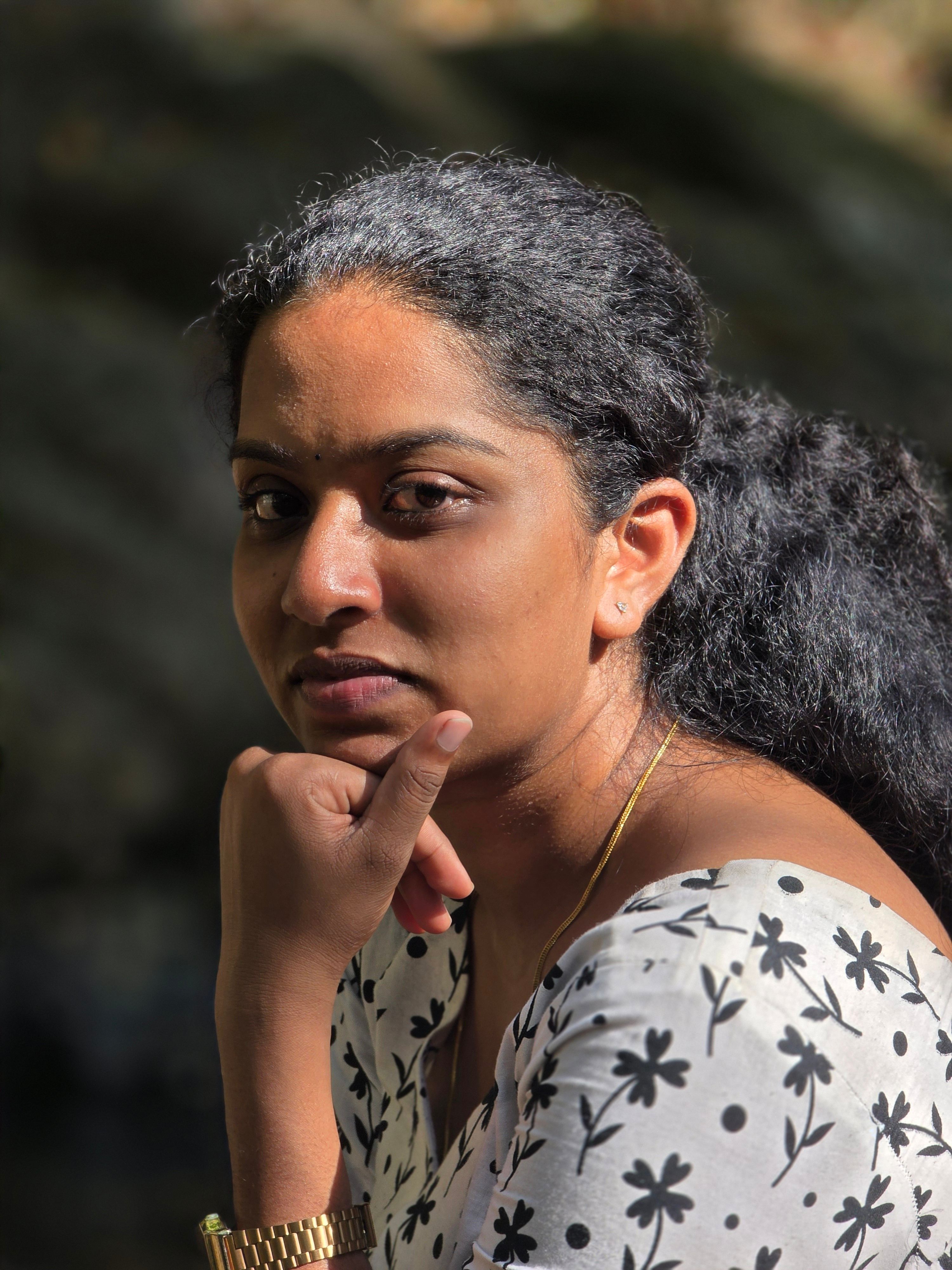 Close-up portrait of a woman in sunlight, exuding introspection and calm.