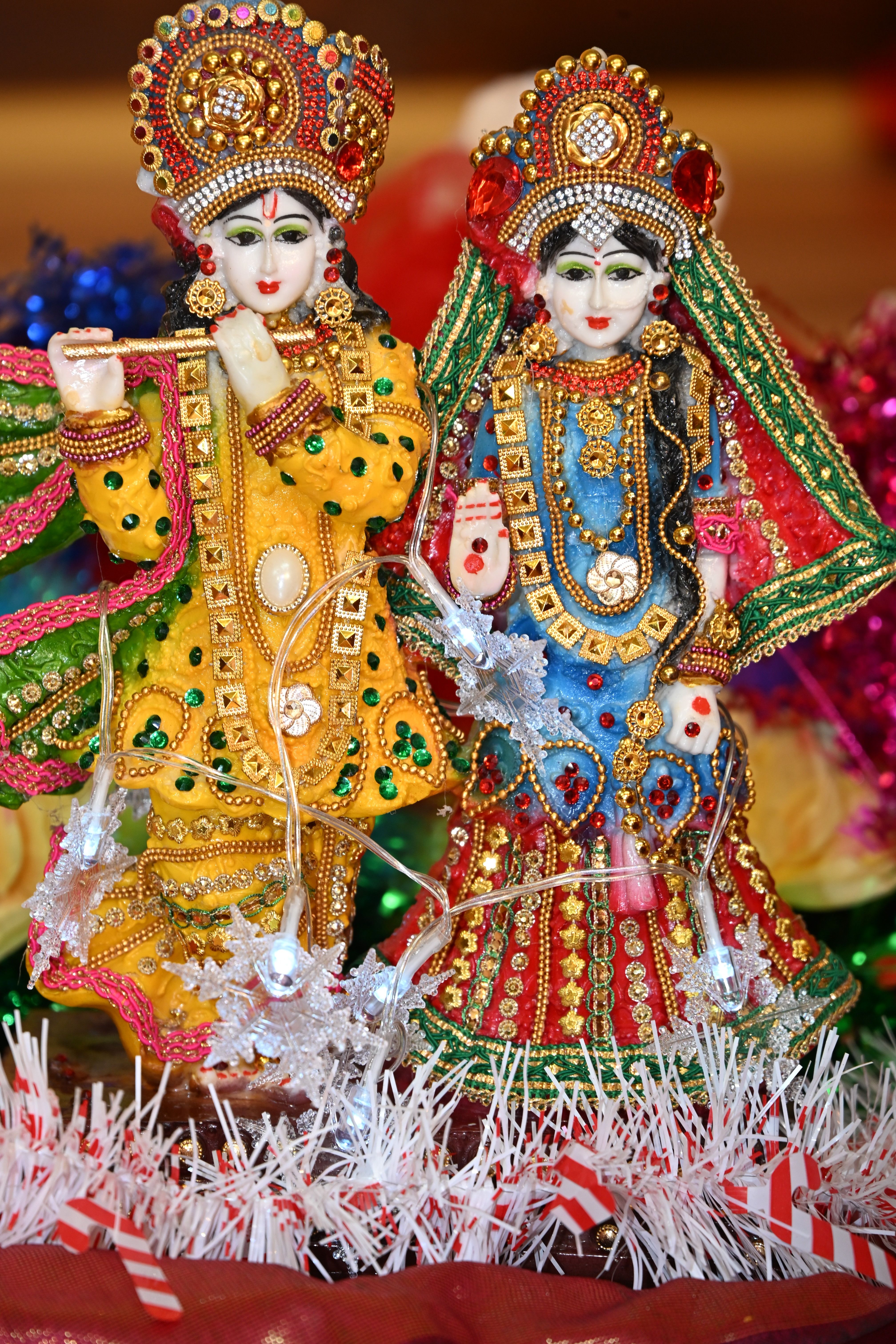 Colorful figurines of Hindu deities adorned with intricate beadwork and traditional attire.