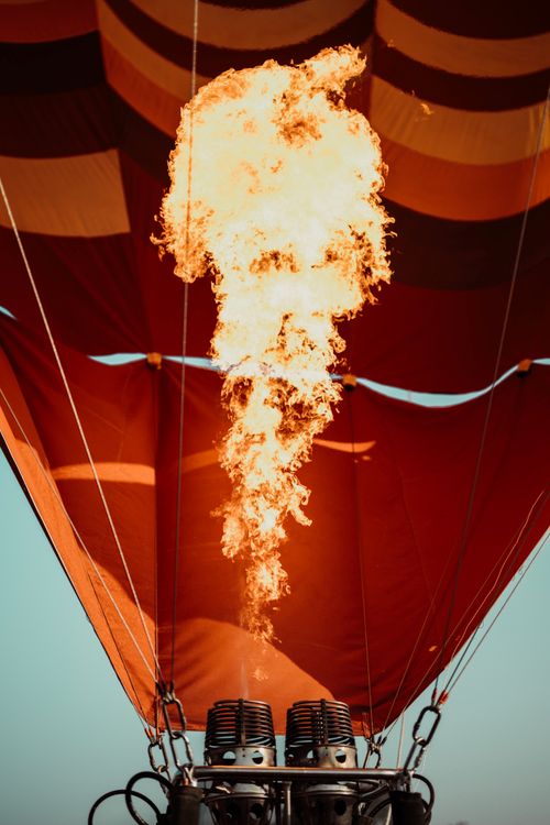 Free Close-up view of flames inside a hot air balloon creating vivid colors against a clear sky. Stock Photo