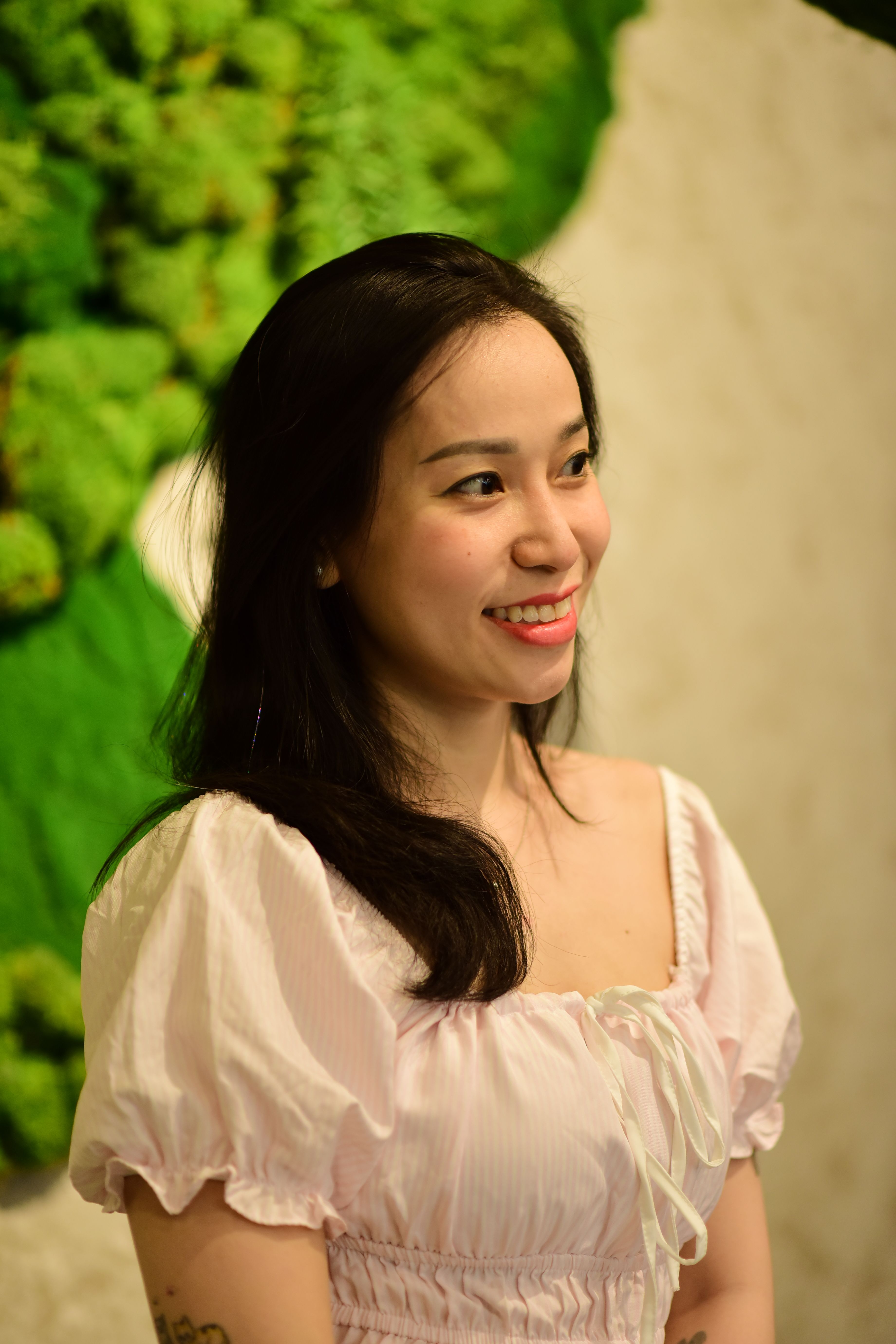 Portrait of a cheerful woman with natural green background indoors.