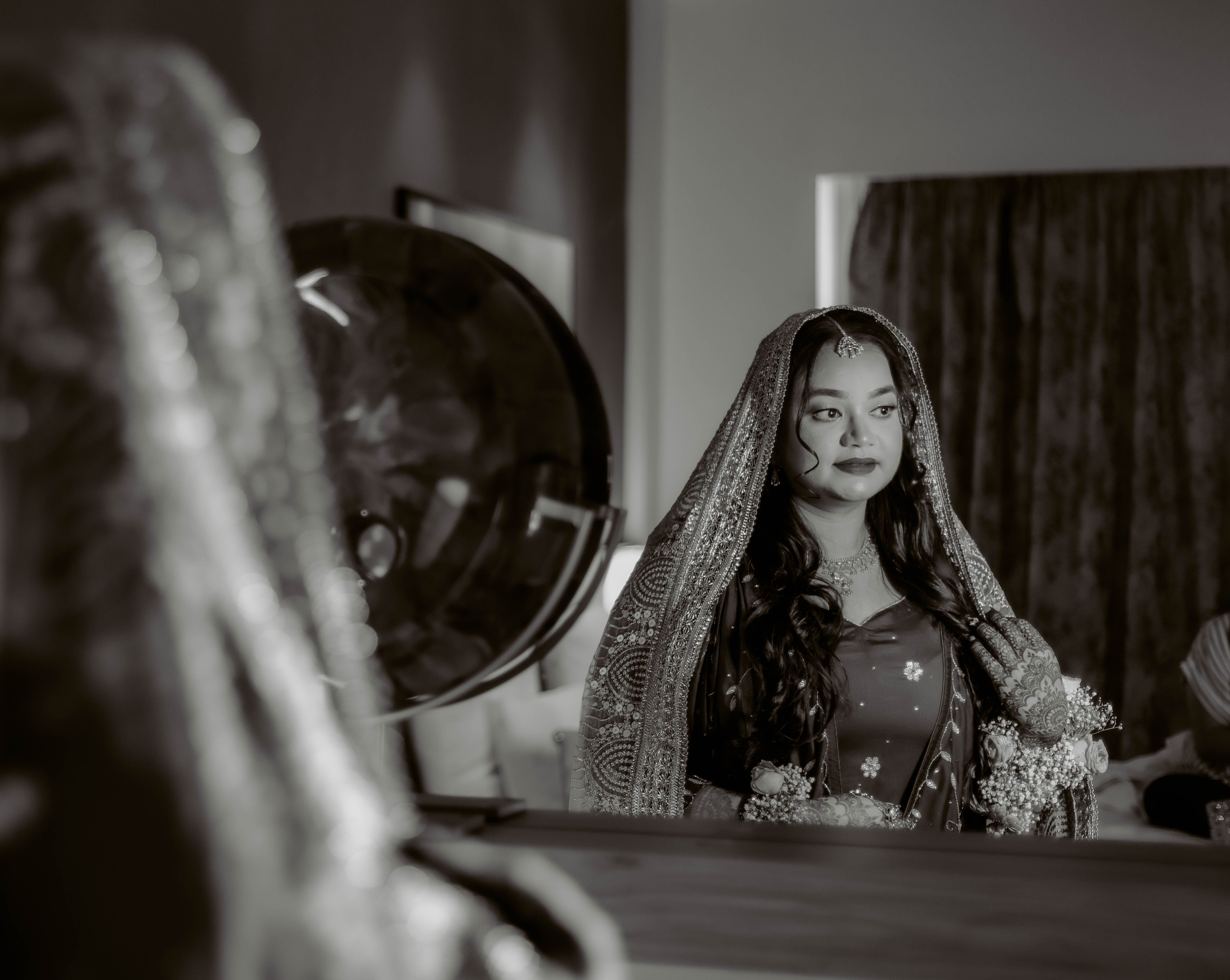 Elegantly dressed bride in traditional attire captured in a thoughtful moment before the ceremony.