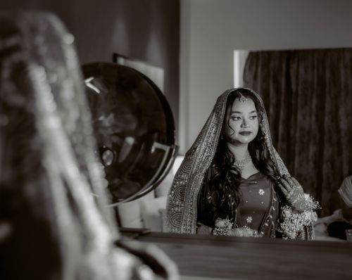 Free Elegantly dressed bride in traditional attire captured in a thoughtful moment before the ceremony. Stock Photo