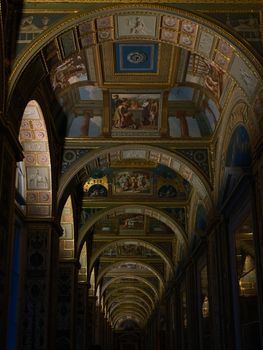 Intricate archway with stunning artistic frescoes in a historic corridor.