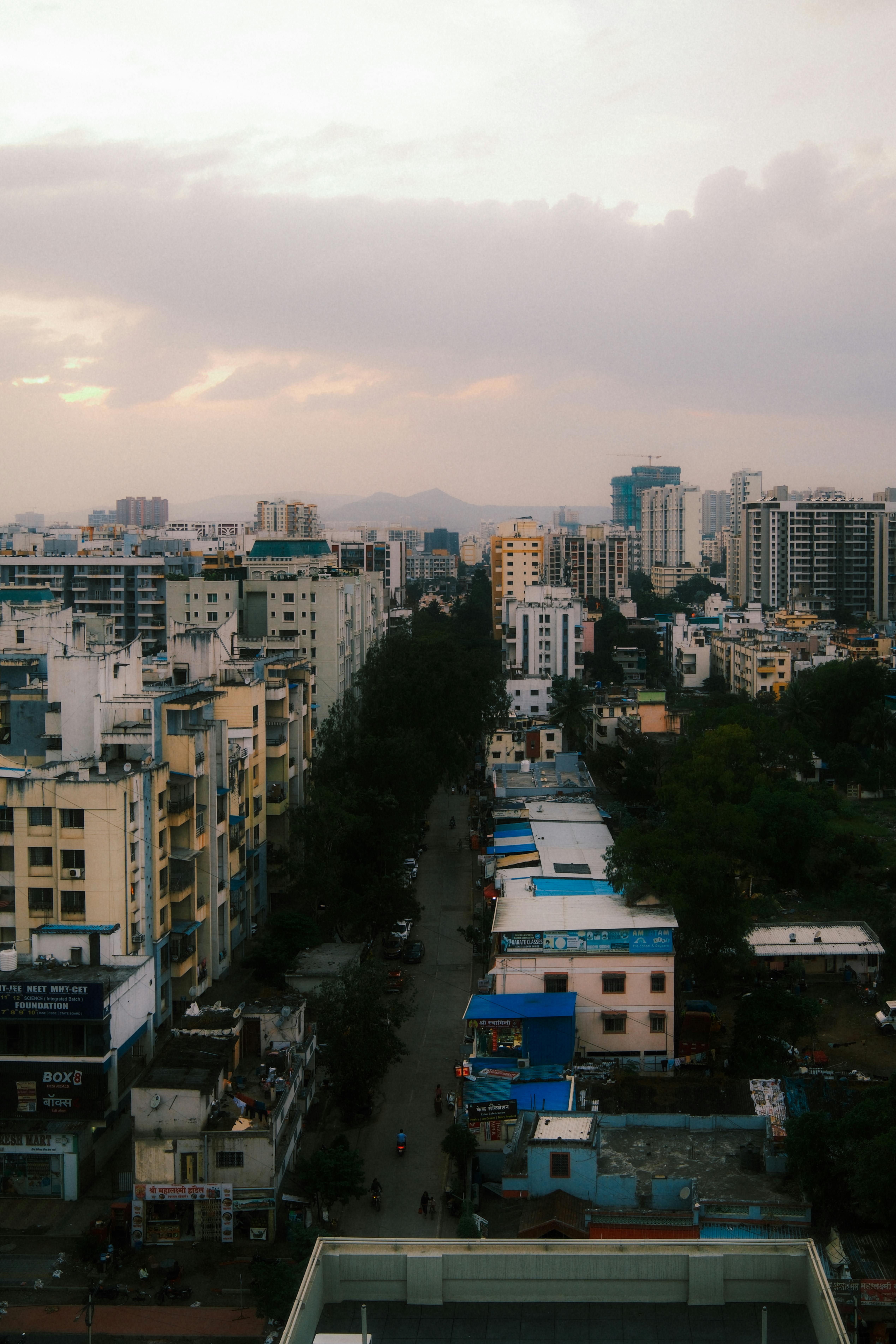Aerial view of a bustling cityscape at dusk, showcasing skyline and urban architecture.