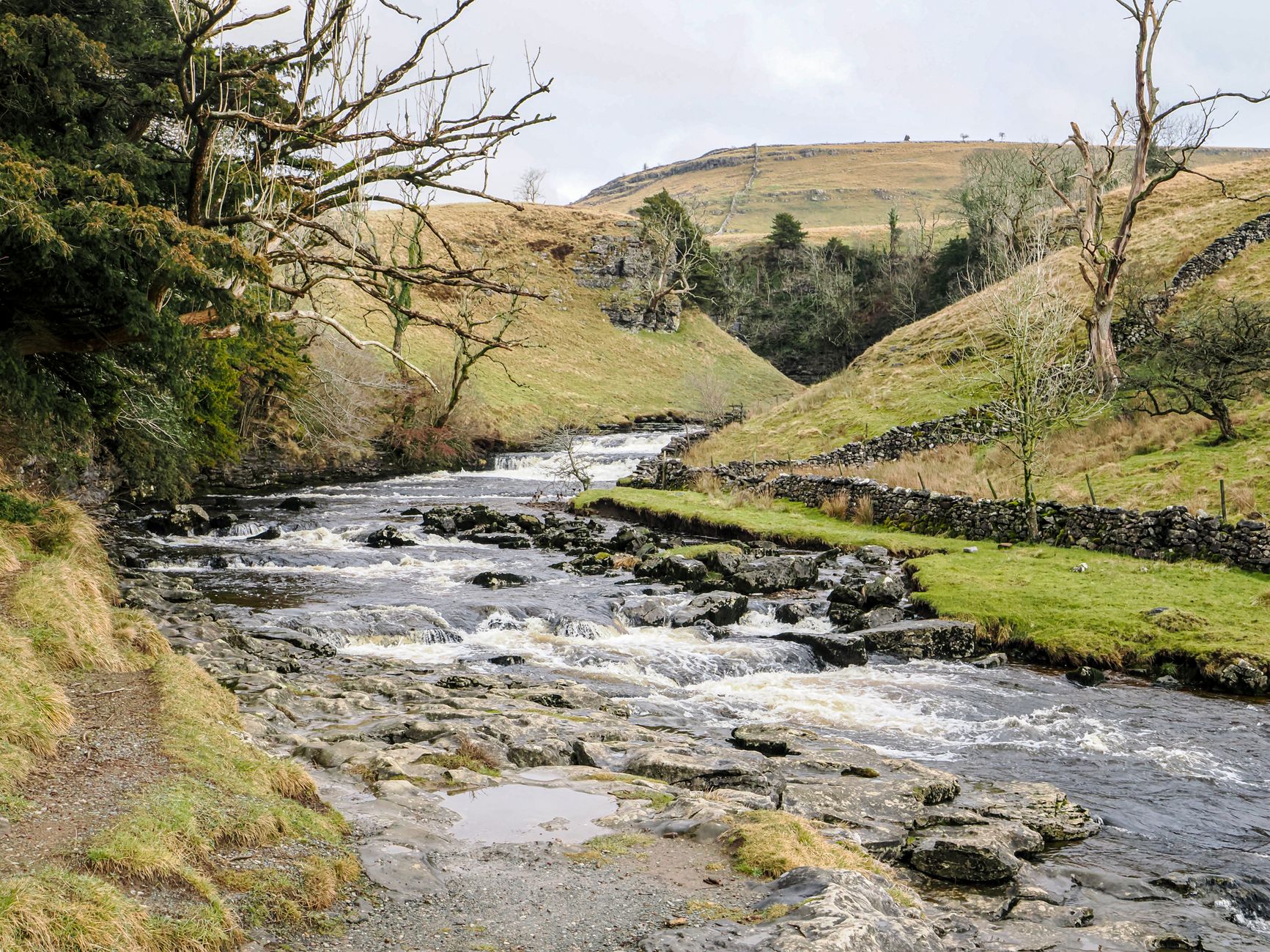 A serene river flowing through the Yorkshire Dales National Park landscape in spring
