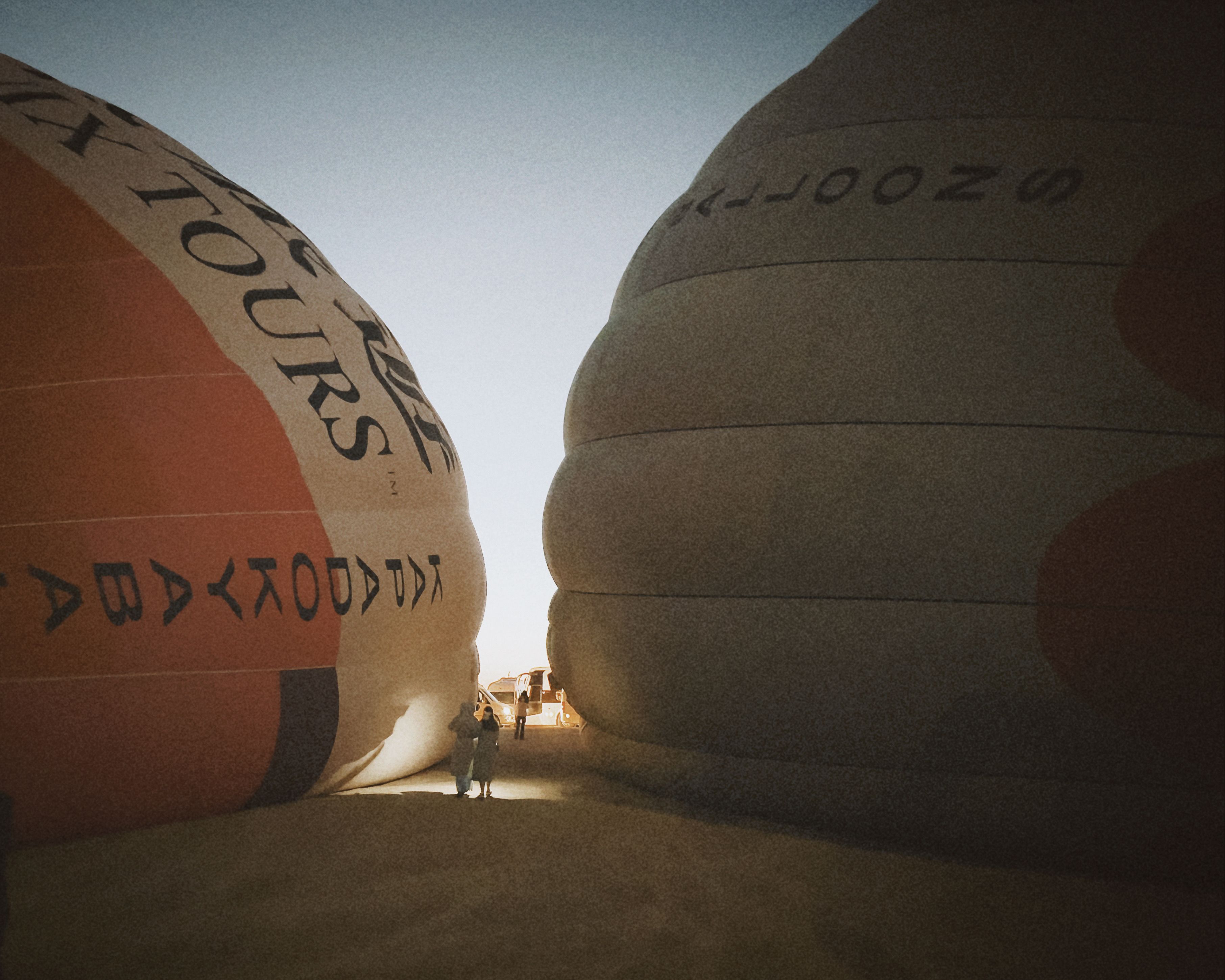 Silhouetted view of hot air balloons with people at sunrise. Serene and adventurous moment.