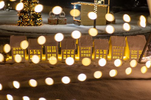 Free Miniature village scene with festive lighting and snow, creating a magical holiday atmosphere. Stock Photo