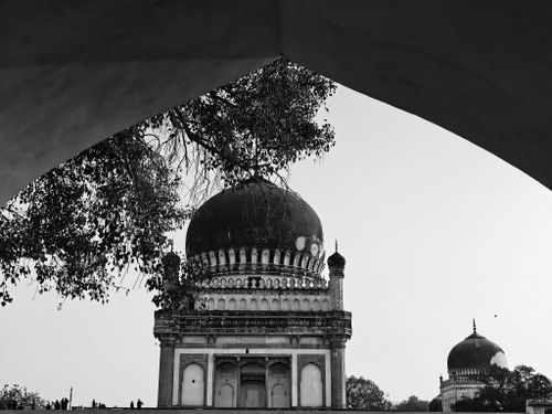 Free Monochrome view of domed tomb framed by an archway, evoking historical architecture. Stock Photo