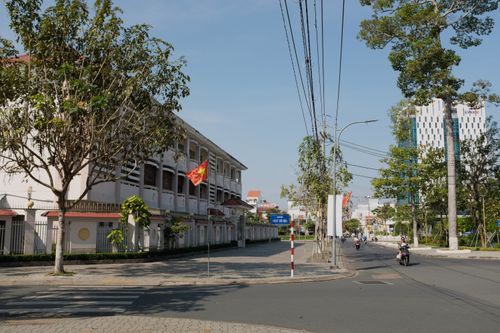 Free Street view of Bến Tre, Vietnam, with a Vietnamese flag and blue sky. Stock Photo