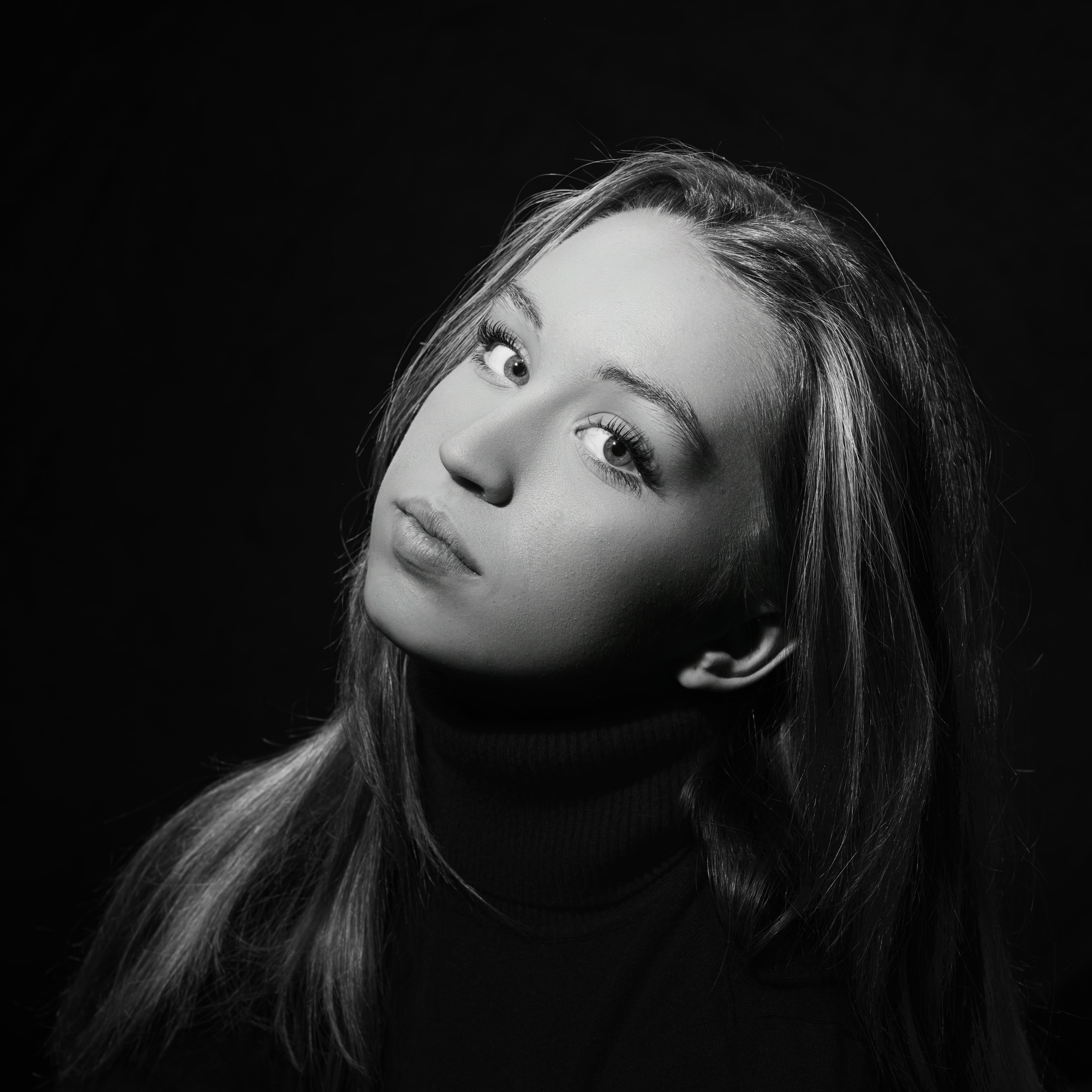 Artistic black and white portrait of a young woman in a classic pose.