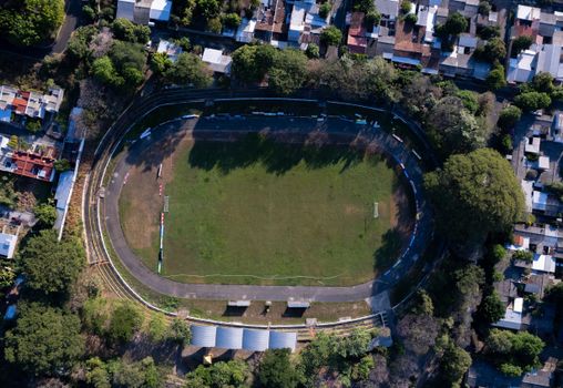 A stunning aerial view of a stadium in Zacatecoluca, El Salvador, surrounded by lush greenery and residential buildings.