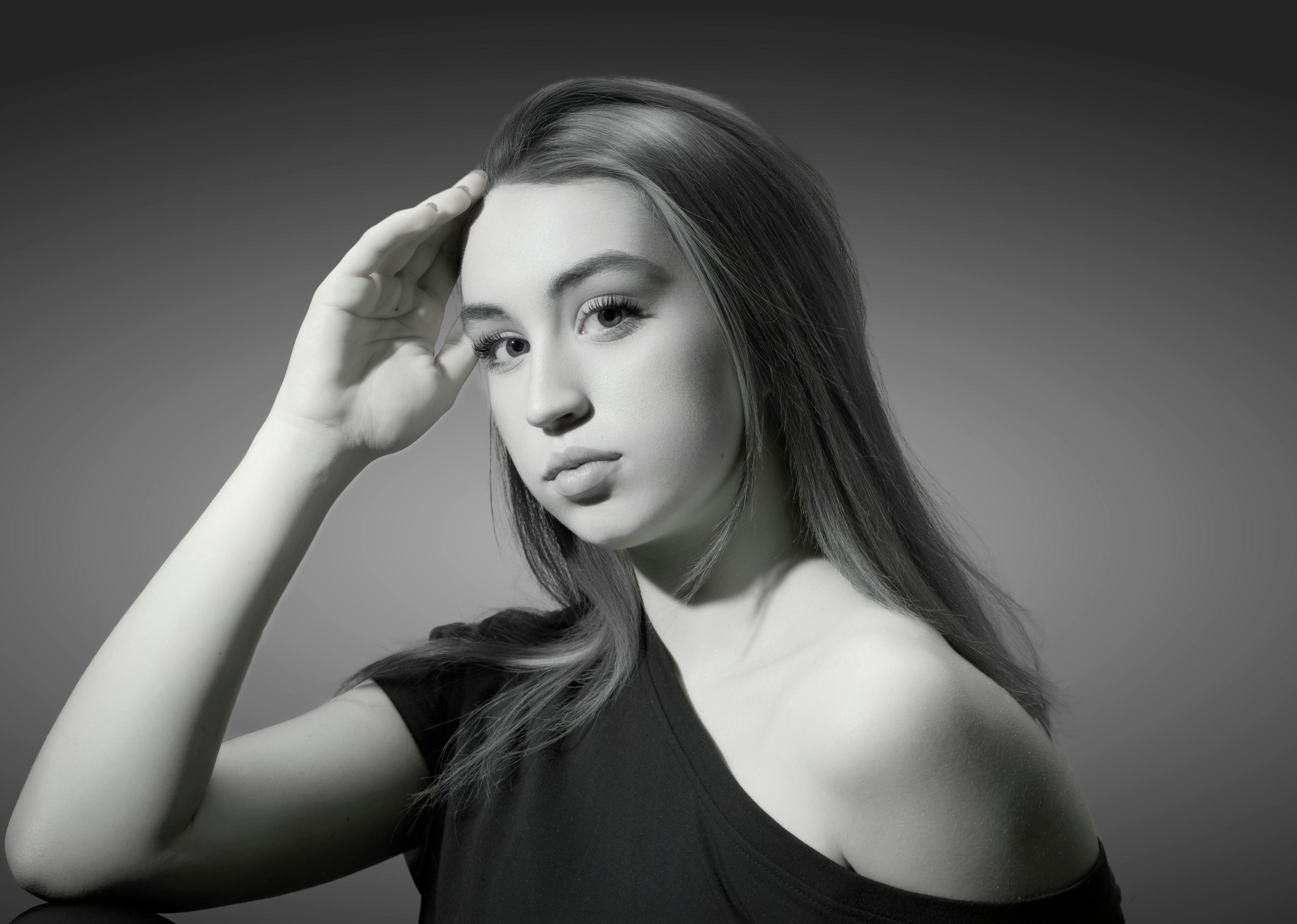 Elegant black and white portrait of a young woman, capturing artistic lighting and beauty.