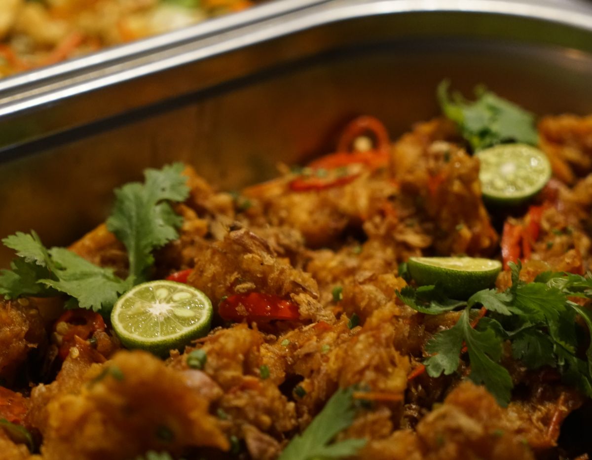 Indian curry with lime and coriander in a steel serving dish