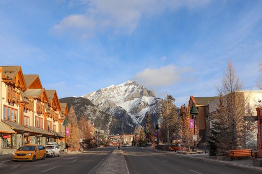 Charming Banff Avenue with snowy mountains in Banff, Alberta, highlighting winter charm.