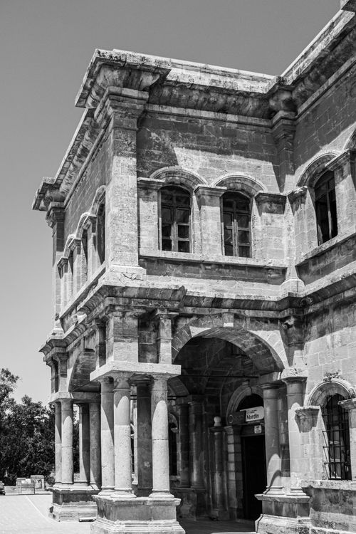 Free Black and white photo of a historic stone building with classic architectural details. Stock Photo