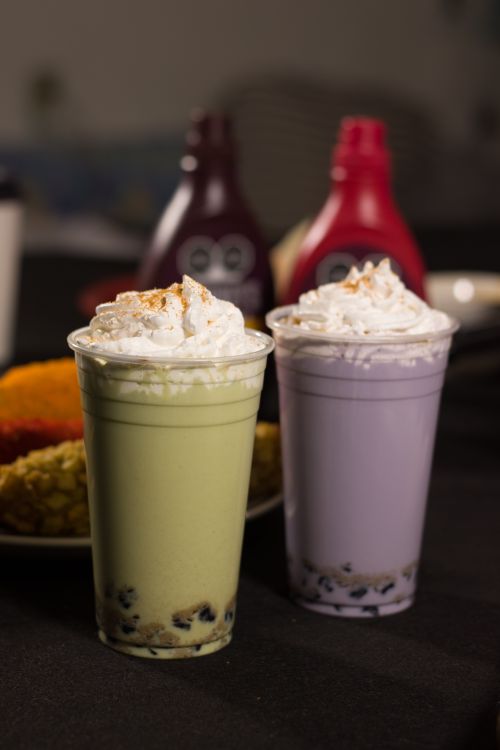 Free Two colorful boba milk teas with whipped cream, featuring vibrant green and purple colors. Stock Photo