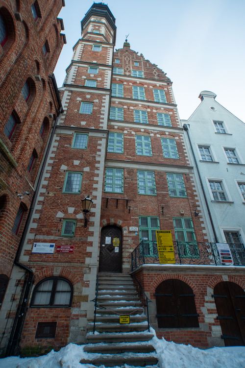 Free Detailed view of a historic brick townhouse under a clear blue sky in winter. Stock Photo