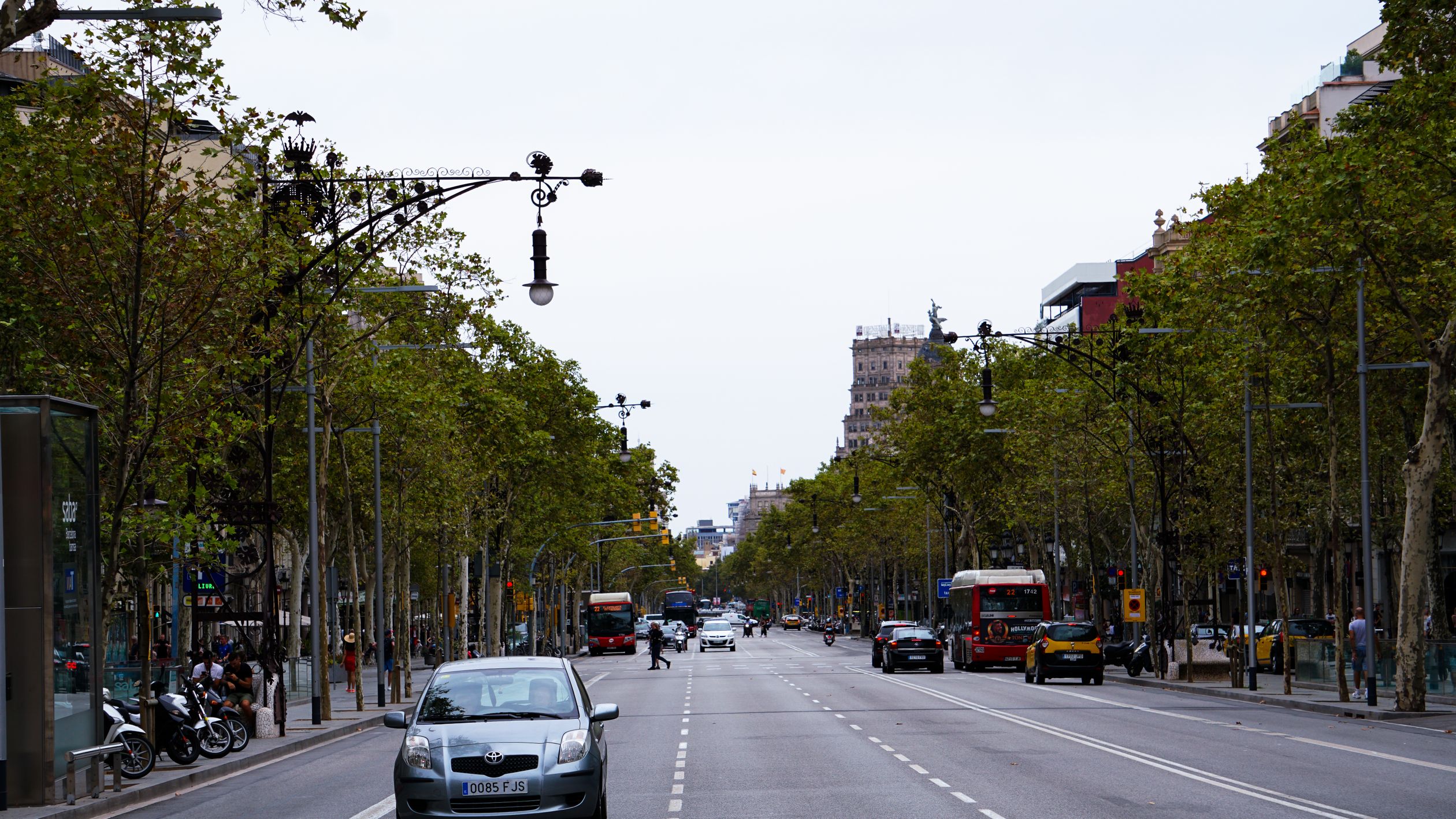 A bustling street view in Barcelona capturing urban transport and architecture